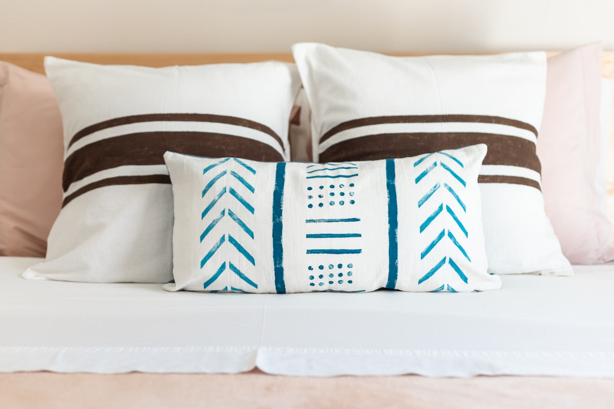 Layered blue and cream bedding in a calm bedroom